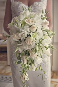 a bridal holding a bouquet of white flowers