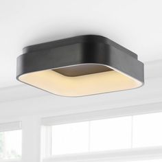 a black square light fixture in a white room