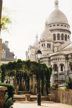 an ornate building with many windows and arches on the front, surrounded by greenery