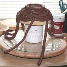 there is a chocolate whip on top of a glass plate next to scissors and other crafting supplies