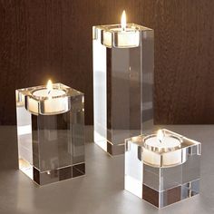 three clear candles sitting next to each other on a table