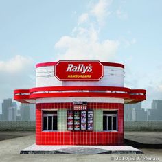 a red and white building with a sign that says rally's hamburgers on it