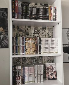 a book shelf filled with lots of books next to pictures on the wall behind it