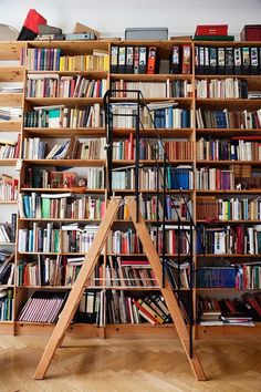 a bookshelf filled with lots of books in a room