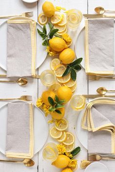 the table is set with lemons and white plates