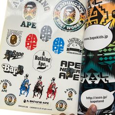 a person holding up a book with various stickers on the front and back cover