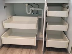 an open closet with white drawers and pipes