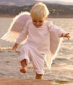 an angel with white wings is walking on the beach