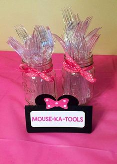 two glass jars with pink bows on them and a sign that says mouse - ka - tools