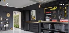 a garage with black cabinets and tools hanging on the wall