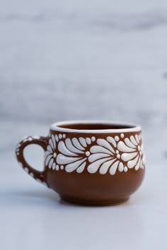 a brown and white coffee cup sitting on top of a table