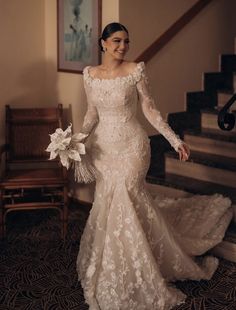 a woman in a wedding dress is walking down the stairs with her hand on her hip