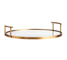 an oval glass and brass tray with two handles on each side, sitting on a white surface