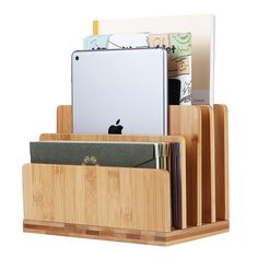 a wooden holder with an ipad and other items in it that are stacked on top of each other