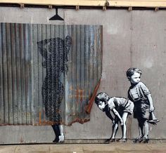 a painting on the side of a building with two children and a dog standing in front of it