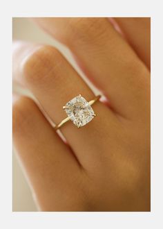 a woman's hand with a diamond ring on it