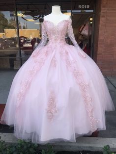 a pink ball gown on display in front of a store