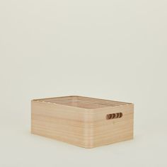 a wooden box with two holes in the middle on a white surface, one is empty