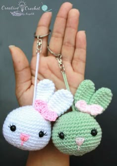 two crocheted keychains that look like bunnies with faces on them