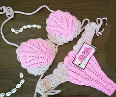 two pink bras with matching headbands on top of a wooden table next to a card