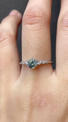 a woman's hand with a diamond ring on top of her finger and an engagement band