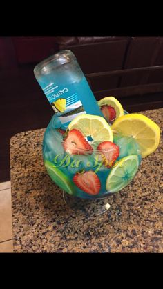 a drink in a glass with lemons, strawberries and lime slices on it