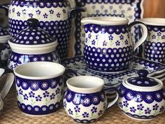 a table topped with lots of blue and white dishes covered in polka dot design pottery