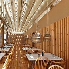 the interior of a restaurant with wooden tables and chairs