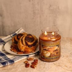 a plate with some food and a candle next to it on a marble counter top