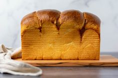 a loaf of bread sitting on top of a wooden cutting board