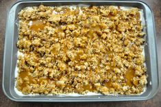 an uncooked casserole dish with caramel sauce and crumbs