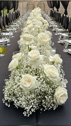 a long table with white flowers and baby's breath