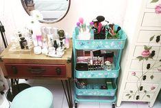 a blue cart with makeup and other items on it next to a dresser in a room