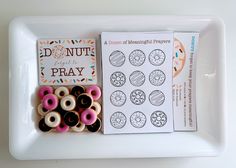 doughnuts are arranged on a white tray next to an adult coloring book and stickers