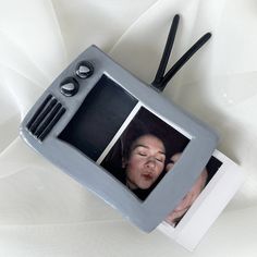 an old fashioned tv with a woman's face on it and two black handles