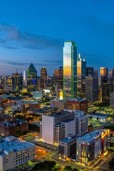 the city skyline is lit up at night in this aerial photo taken from across the street