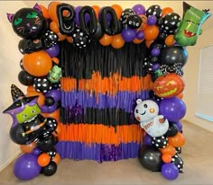 a halloween balloon arch decorated with black, orange and purple balloons