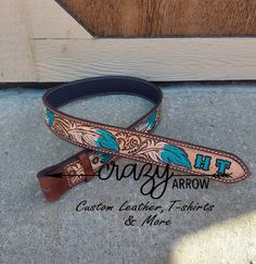 a brown and blue leather belt sitting on top of a cement floor next to a wooden door