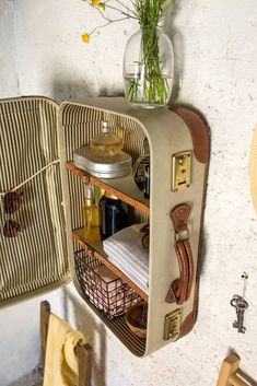 an old fashioned suitcase is open to show the contents in it's storage compartment