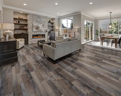 a living room filled with furniture and a fire place next to a dining room table