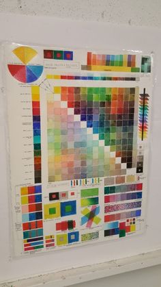 a white frame with some different colored swatches on it and a wall in the background