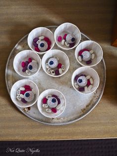 there are many small cups with buttons in them on the tray and one is empty