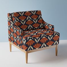 an orange and blue patterned chair with wooden legs