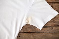 a white t - shirt laying on top of a wooden floor