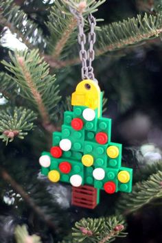 a lego christmas tree ornament hanging from a pine tree