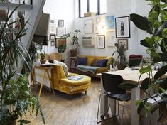 a living room filled with furniture and plants