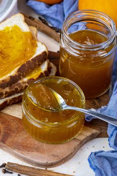 peanut butter and jelly sandwiches on a cutting board with oranges in the back ground