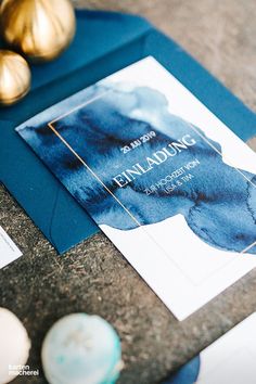 an elegant blue and gold wedding suite is displayed on a table with other items in the background