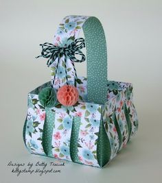 an open gift bag with flowers and polka dots on the bottom, tied in a ribbon