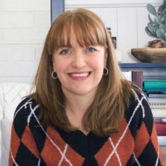 a woman sitting on a couch smiling at the camera